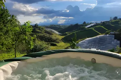 a jacuzzi tub with a view of the water at Cabaña Entre Aguacates, Refugio en Marinilla in Marinilla