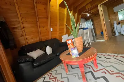 a living room with a black couch and a table at Cabaña Entre Aguacates, Refugio en Marinilla in Marinilla