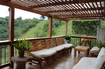 a porch with benches and a pergola at Cabaña Entre Aguacates, Refugio en Marinilla in Marinilla