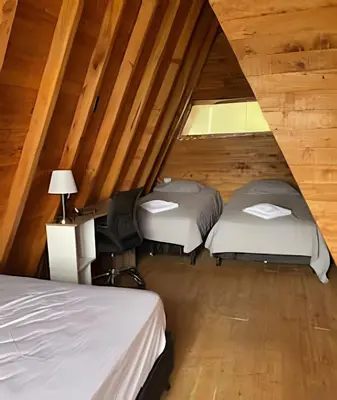 two beds in a room with wooden ceilings at Cabaña Entre Aguacates, Refugio en Marinilla in Marinilla