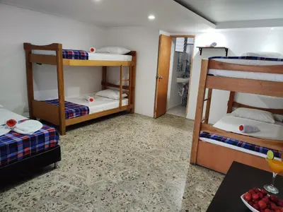 a room with three bunk beds and a table at Absolute Hotel & Hostel Boutique in Medellín