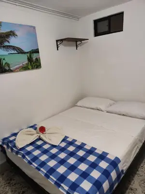 a bed with a blue and white checkered blanket at Absolute Hotel & Hostel Boutique in Medellín