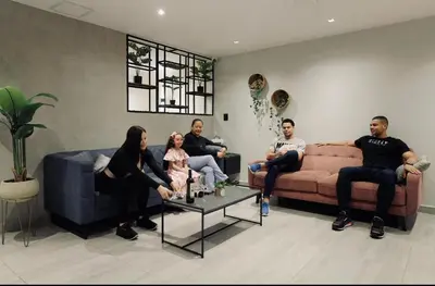 a group of people sitting in a living room at Casa Moderna Laureles con Jacuzzi y 7 Baños in Medellín