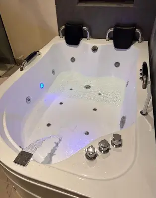 a white bath tub with two chairs in it at Casa Moderna Laureles con Jacuzzi y 7 Baños in Medellín