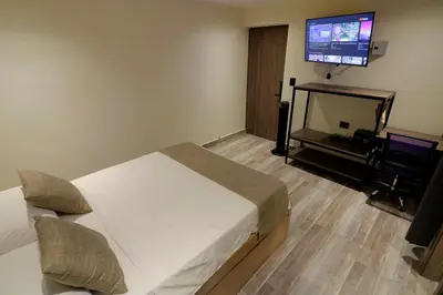 a bedroom with a bed and a flat screen tv at Casa Moderna Laureles con Jacuzzi y 7 Baños in Medellín