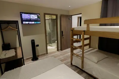 a room with two bunk beds and a television at Casa Moderna Laureles con Jacuzzi y 7 Baños in Medellín