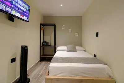 a bedroom with two beds and a flat screen tv at Casa Moderna Laureles con Jacuzzi y 7 Baños in Medellín