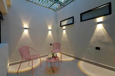 two chairs and a table in a room with lights at Casa Moderna Laureles con Jacuzzi y 7 Baños in Medellín