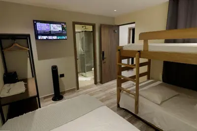 a room with two bunk beds and a television at Casa Moderna Laureles con Jacuzzi y 7 Baños in Medellín