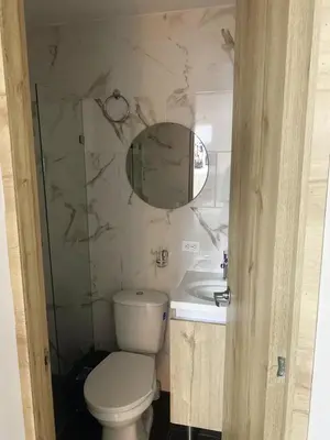 a bathroom with a toilet and a sink and a mirror at Hotel Boutique San Joaquin Plaza in Medellín