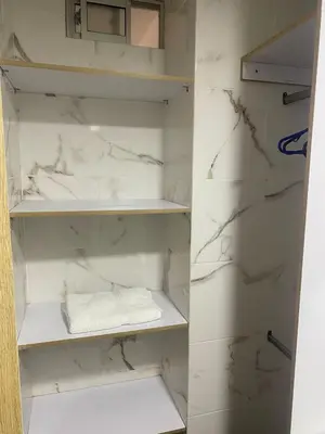 a closet with white marble walls and white shelves at Hotel Boutique San Joaquin Plaza in Medellín