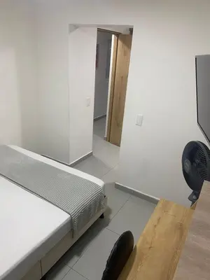 a bedroom with a bed and a fan on the floor at Hotel Boutique San Joaquin Plaza in Medellín