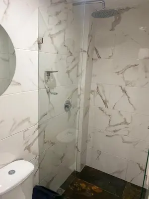 a bathroom with a glass shower with a toilet at Hotel Boutique San Joaquin Plaza in Medellín