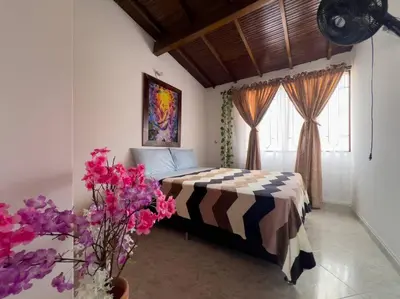 a bedroom with a bed and a vase of flowers at Excepcional Casa Privada para Familias y Grupos - Excelente Ubicación in Medellín