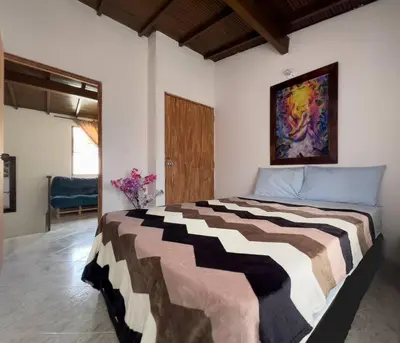 a bedroom with a bed with a painting on the wall at Excepcional Casa Privada para Familias y Grupos - Excelente Ubicación in Medellín