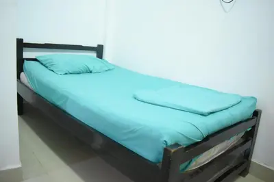 a bed with blue sheets and pillows on it at Shaddai restaurante y hospedaje in Puerto Triunfo