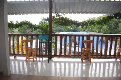 two chairs and a table on a balcony at Shaddai restaurante y hospedaje in Puerto Triunfo