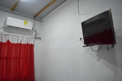 a tv hanging on a wall next to a red curtain at Shaddai restaurante y hospedaje in Puerto Triunfo