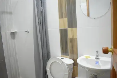 a bathroom with a toilet and a sink and a mirror at Shaddai restaurante y hospedaje in Puerto Triunfo
