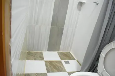 a bathroom with a toilet and a checkered floor at Shaddai restaurante y hospedaje in Puerto Triunfo