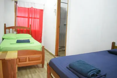 a bedroom with two beds and a mirror at Shaddai restaurante y hospedaje in Puerto Triunfo
