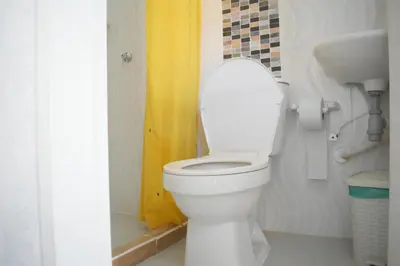 a bathroom with a toilet with the lid up at Shaddai restaurante y hospedaje in Puerto Triunfo