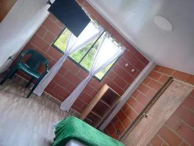a room with a green chair and a window at HOSPEDAJE MARIN in Concepción