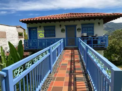 a blue bridge leading to a house with a blue door at Apartahotel Villa Carolina 3 in Jericó
