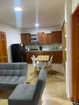a living room with a table and a kitchen at Apartahotel Villa Carolina 3 in Jericó