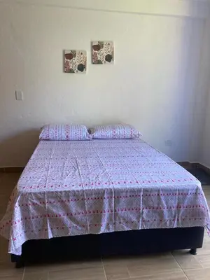 a bedroom with a bed with a pink blanket at Apartahotel Villa Carolina 3 in Jericó