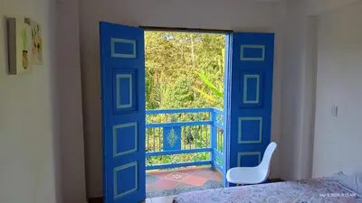 a blue door with a window in a bedroom at Apartahotel Villa Carolina 3 in Jericó