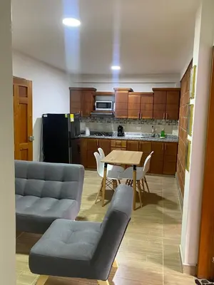 a living room with a table and chairs and a kitchen at Apartahotel Villa Carolina 3 in Jericó