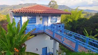 a blue and white house with a balcony at Apartahotel Villa Carolina 3 in Jericó