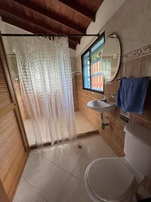 a bathroom with a toilet and a sink and a mirror at La Escondida, con acceso al lago in Guatapé