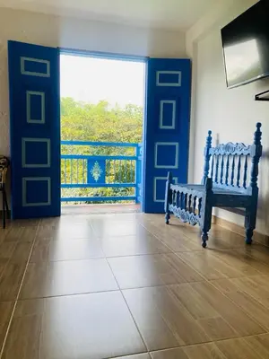 a living room with a blue door and a bench at Apartahotel Villa Carolina 4 in Jericó