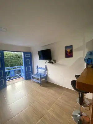 a living room with a tv and a bench and a window at Apartahotel Villa Carolina 4 in Jericó