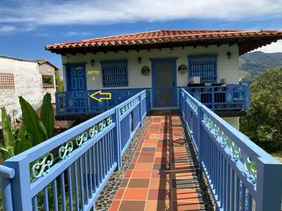 a blue bridge leading to a house with a blue door at Apartahotel Villa Carolina 4 in Jericó