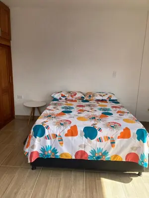 a bed with a colorful comforter in a bedroom at Apartahotel Villa Carolina 4 in Jericó