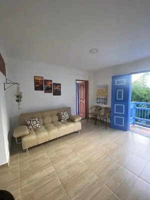 a living room with a couch and a blue door at Apartahotel Villa Carolina 4 in Jericó