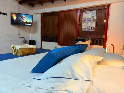 a person laying on a bed watching a tv at Cabaña & glamping para grupos de 4 a 6 personas, cerca al parque y con avistamiento de aves in Jardin