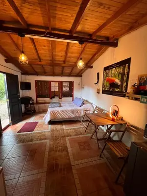 a bedroom with a bed and a table in it at Cabaña & glamping para grupos de 4 a 6 personas, cerca al parque y con avistamiento de aves in Jardin