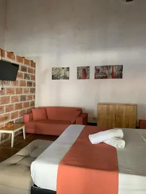 a living room with a bed and a couch at Casa hotel Dulce Candelaria in Santa Fe de Antioquia