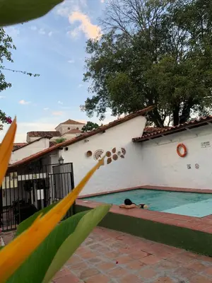 a person laying on the side of a swimming pool at Casa hotel Dulce Candelaria in Santa Fe de Antioquia