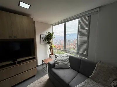 a living room with a couch and a large window at Espectacular apt moderno en el poblado by Hoost in Medellín