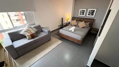 a living room with a couch and a bed at Espectacular apt moderno en el poblado by Hoost in Medellín