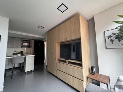 a living room with a flat screen tv in a wooden cabinet at Espectacular apt moderno en el poblado by Hoost in Medellín