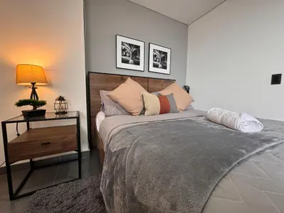a bedroom with a bed and a table with a lamp at Espectacular apt moderno en el poblado by Hoost in Medellín