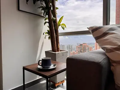 a room with a table with a coffee cup on it at Espectacular apt moderno en el poblado by Hoost in Medellín