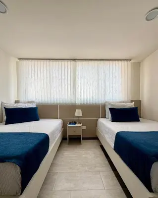 a bedroom with two beds and a window at Hotel Boutique Paralela Real. in Manizales