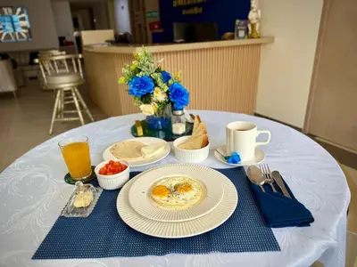 a table with plates of eggs and bread on it at Hotel Boutique Paralela Real. in Manizales